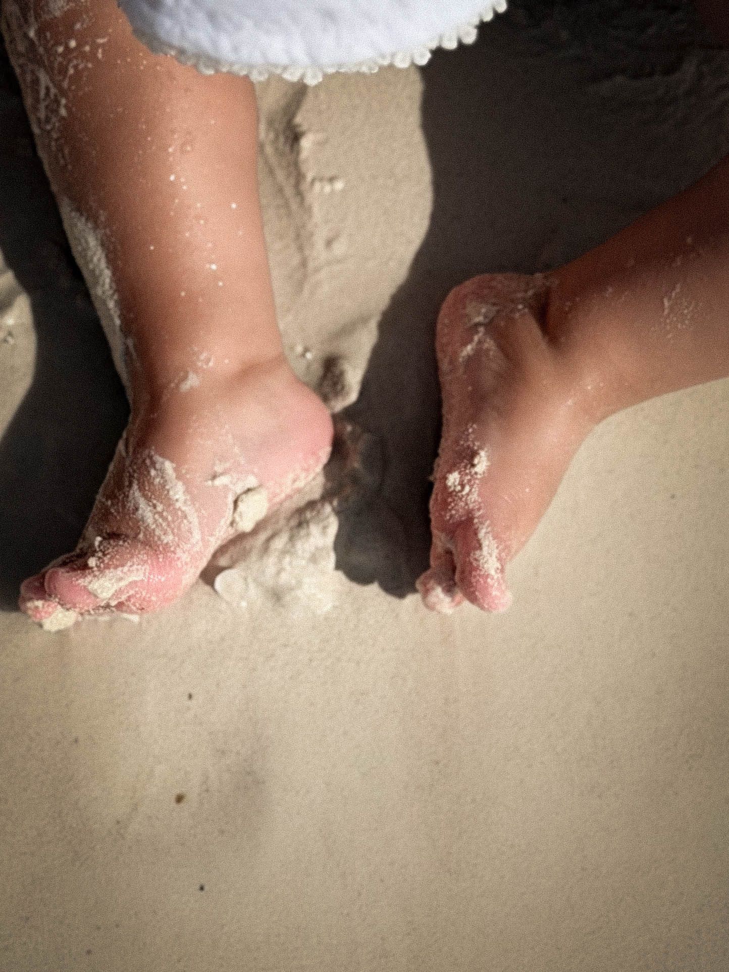 Close up of young a young child's bare sandy feet