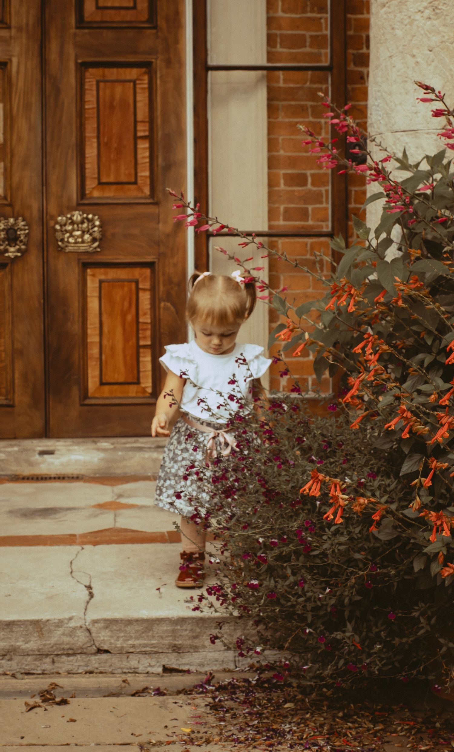 Young child standing in front of ornate red doors
