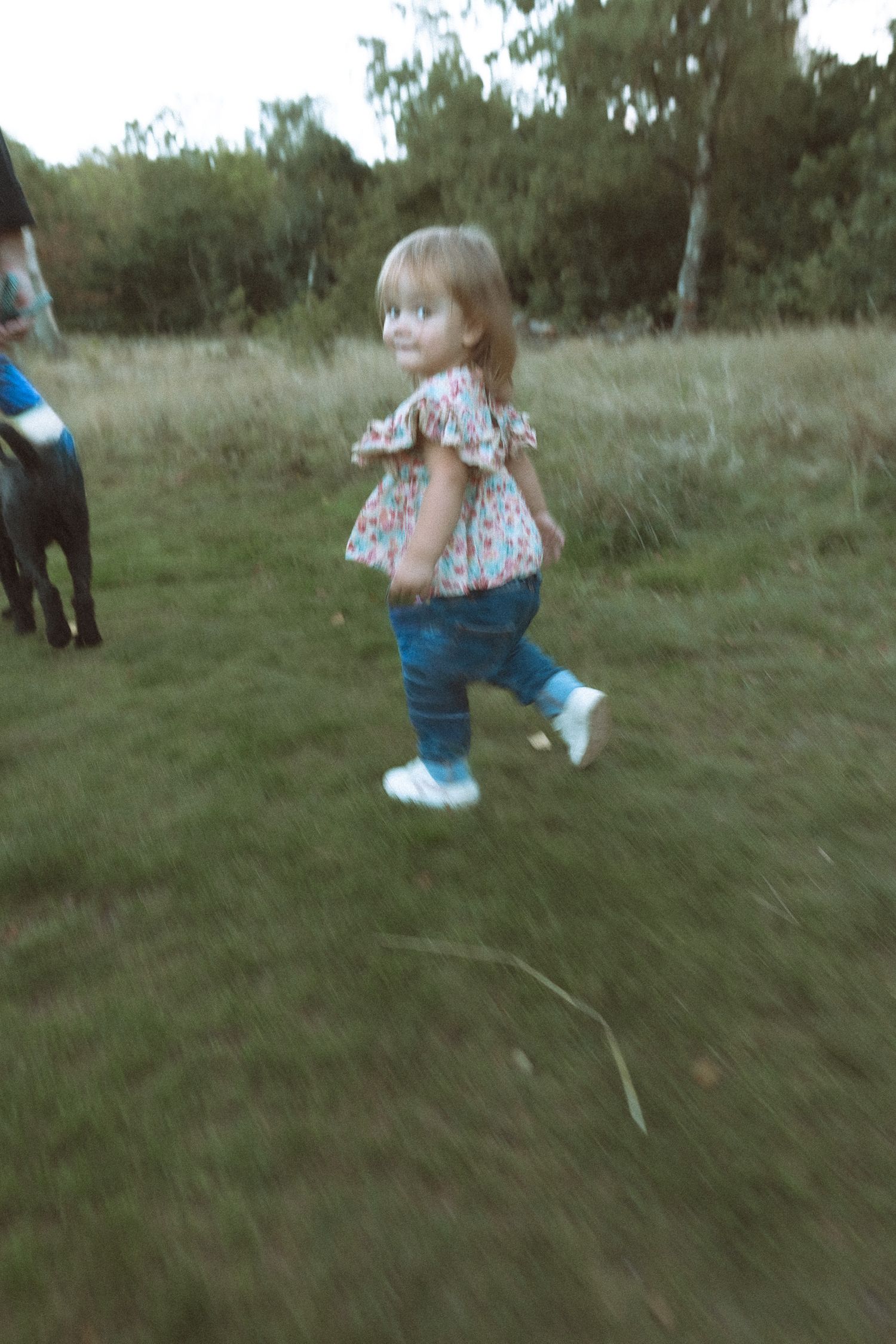 Young child running across the grass outdoors