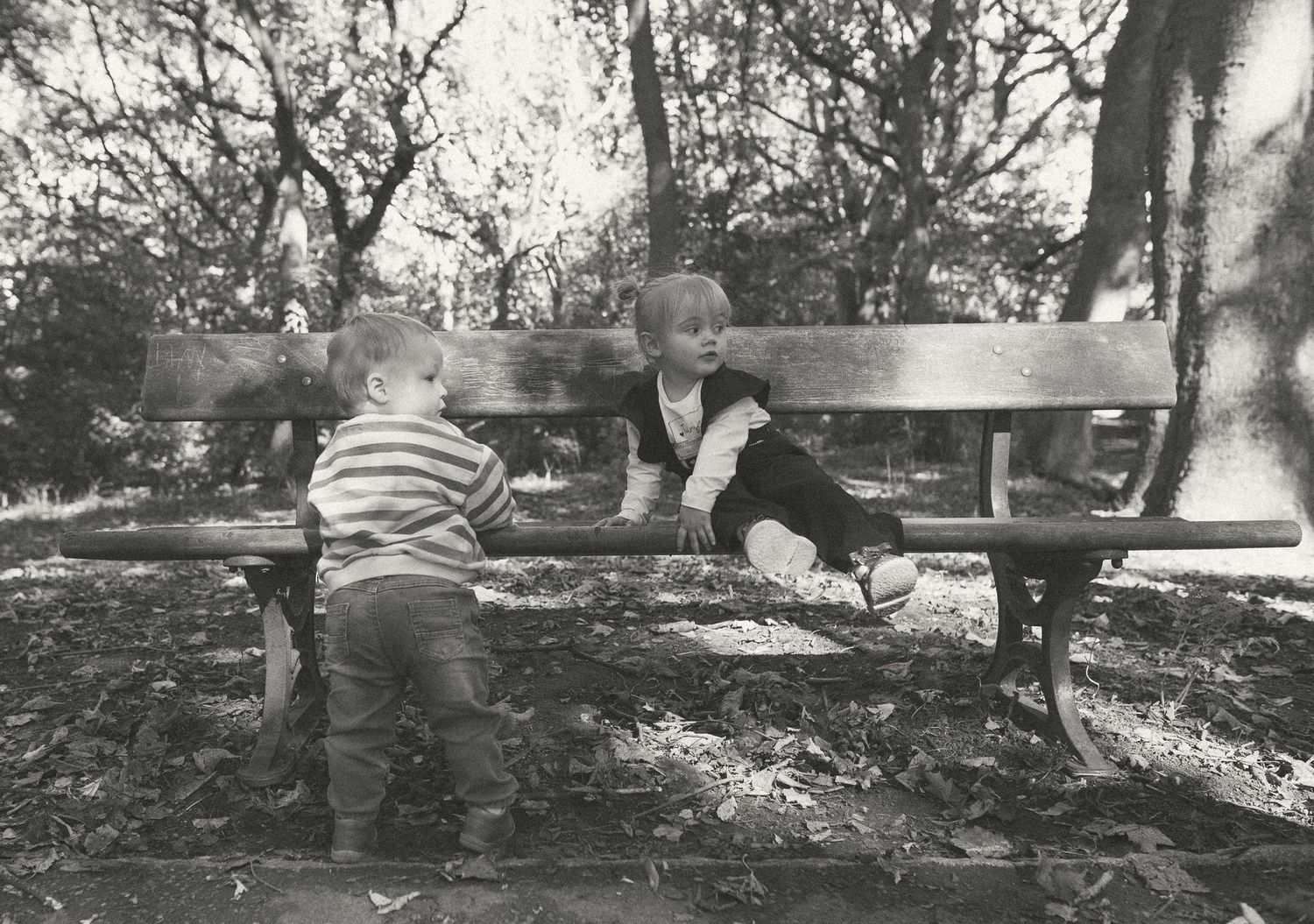 Black and white photograph of two children on a bench