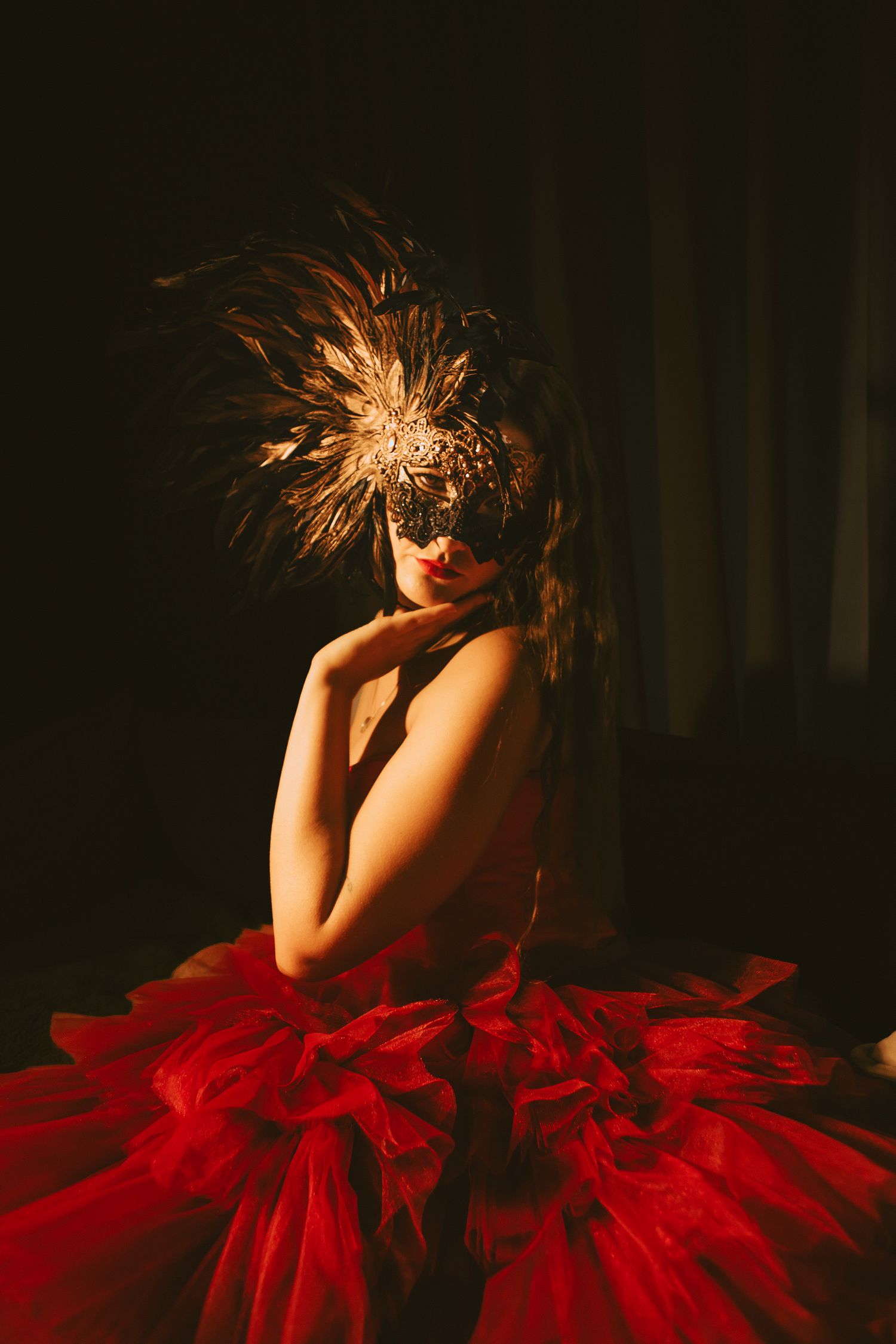 Woman holding chin in ornate mask