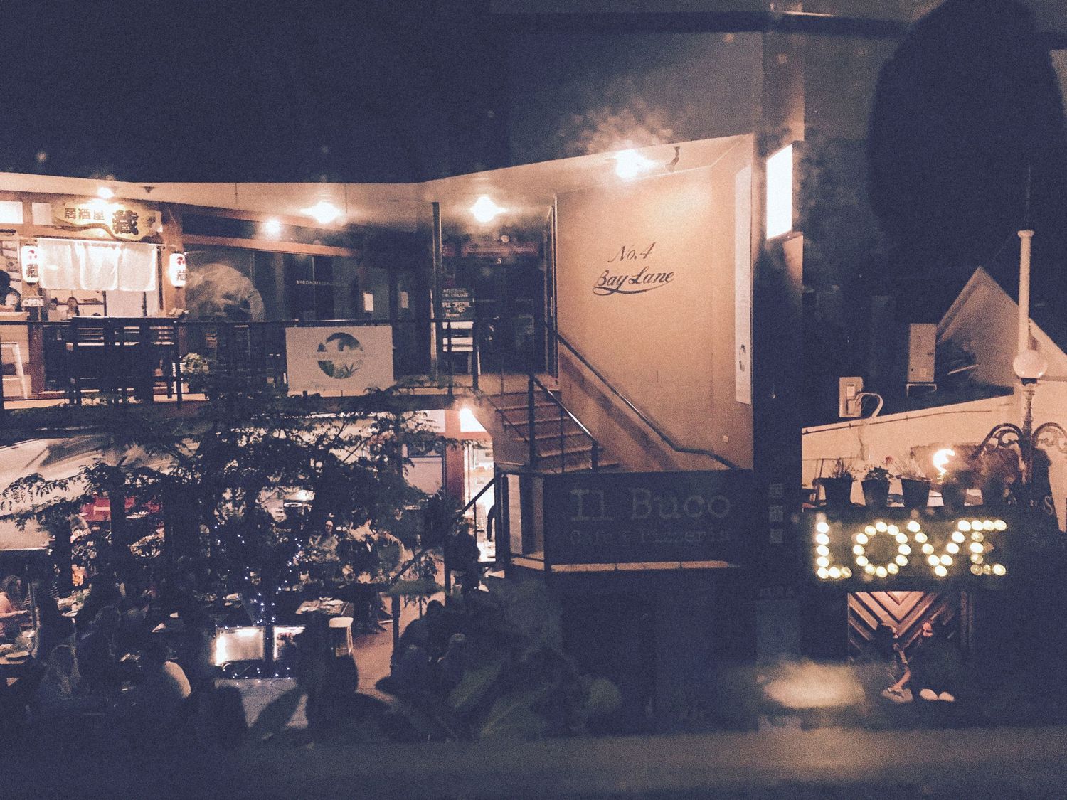 Cozy outdoor restaurant at night with warm lights and a glowing LOVE sign display.