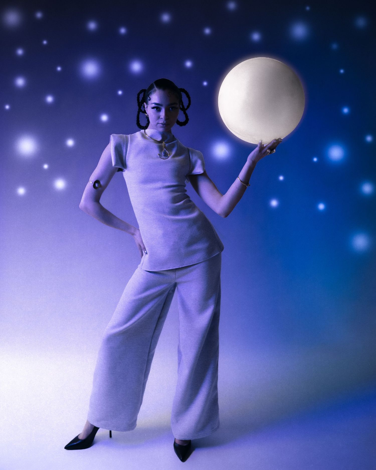 Woman in white outfit holds glowing moon orb against starry blue background.
