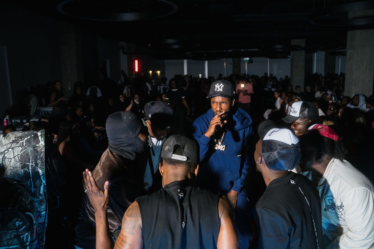Crowd of attendees gathered in a dark venue at an urban fashion and music event.