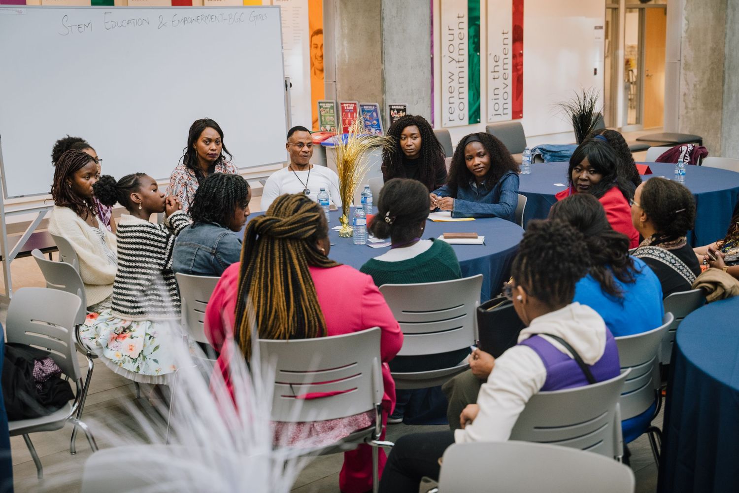 Diverse group of students engaged in roundtable discussion in colorful classroom.