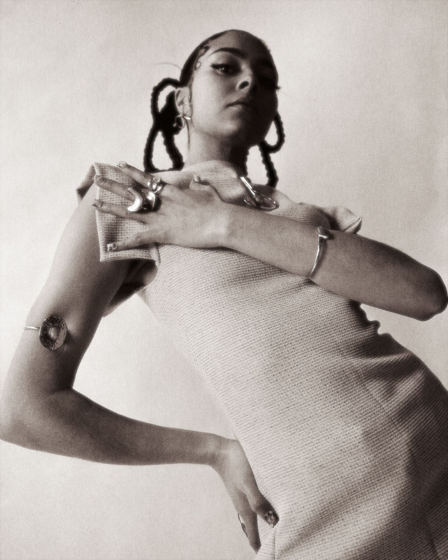 Black and white portrait of woman in ribbed dress adorned with silver jewelry.