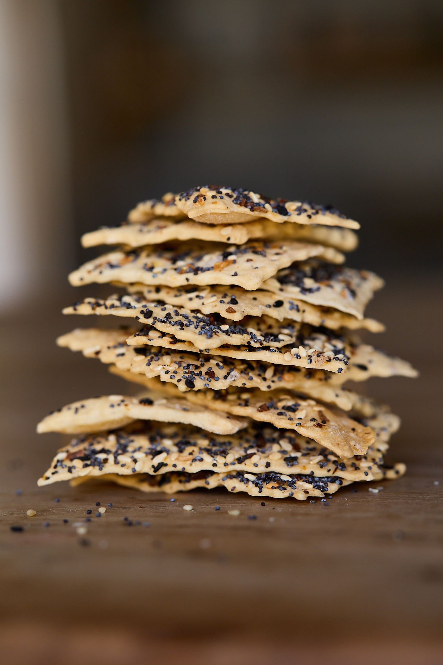 Stack of Georgia Sourdough Everything spice crackers on rustic wood table.
