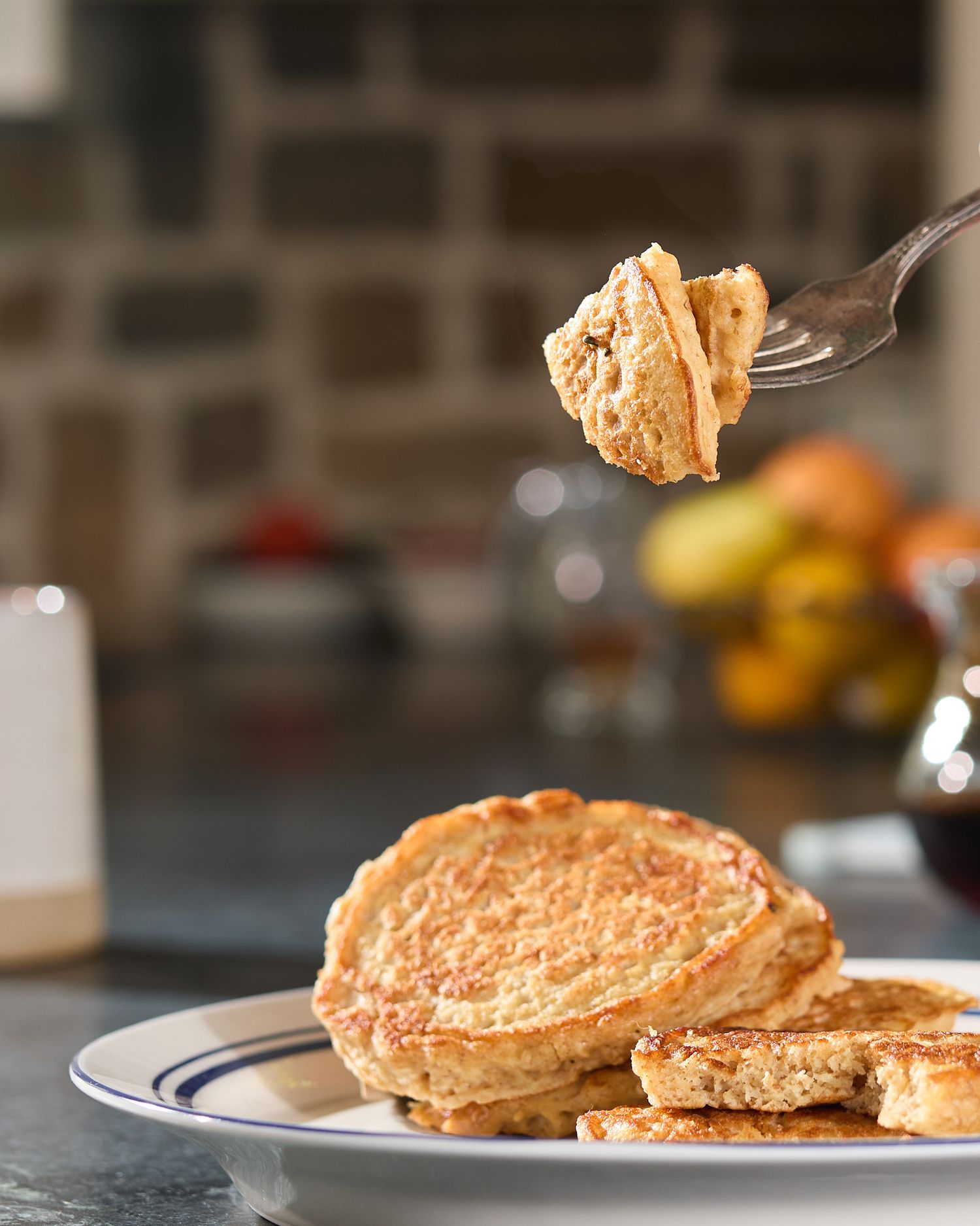 GoodGate Foods' Harvest pancakes on a plate with a fork lifting a bite, photographed in a warm kitchen setting.