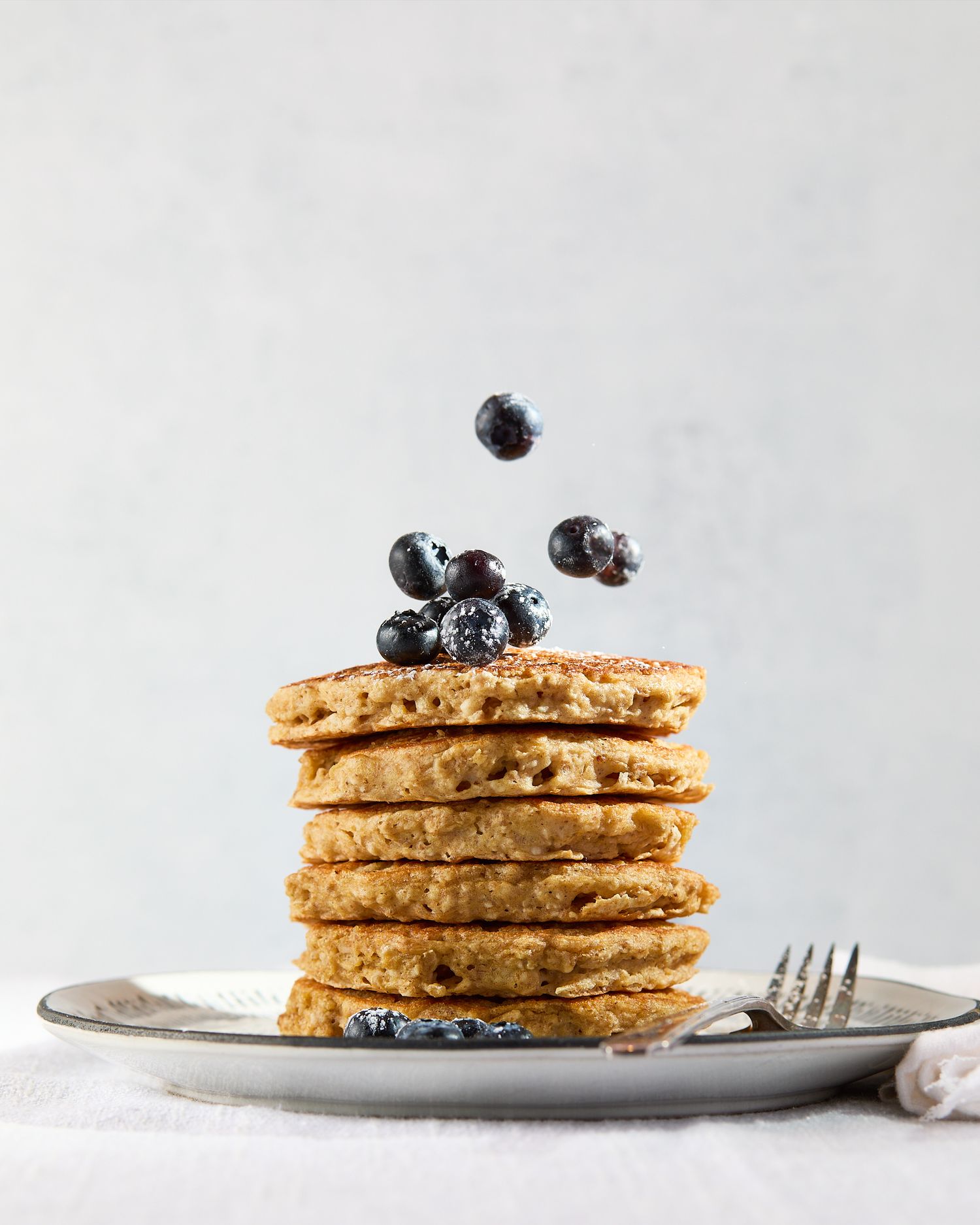 GoodGate Foods Harvest pancakes topped with fresh blueberries photographed against a light, minimalist background.