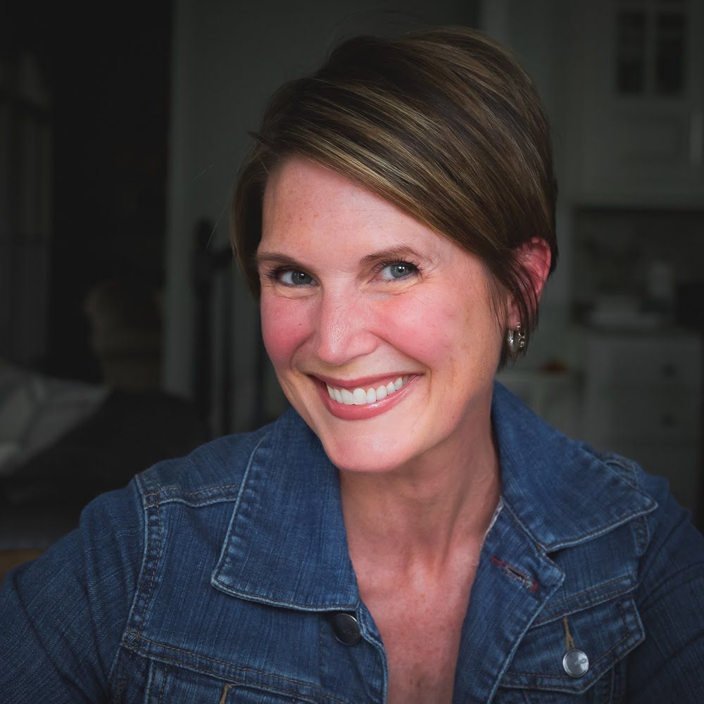 Portrait of Atlanta food and product photographer, Kerrieann in a lived-in kitchen and denim shirt.