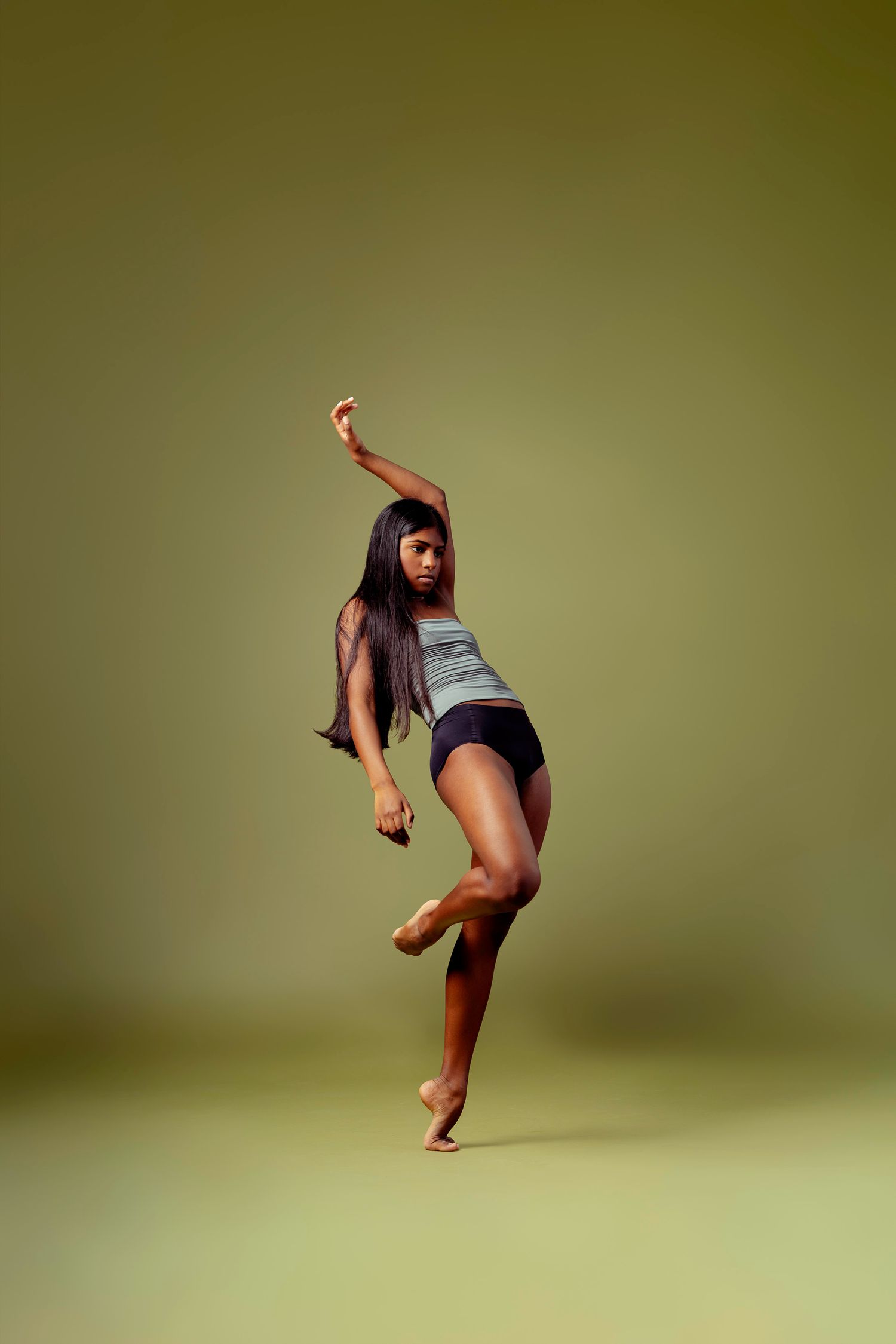 A dancer performs a dynamic high kick sequence against a green backdrop in a series of connected motion photographs.
