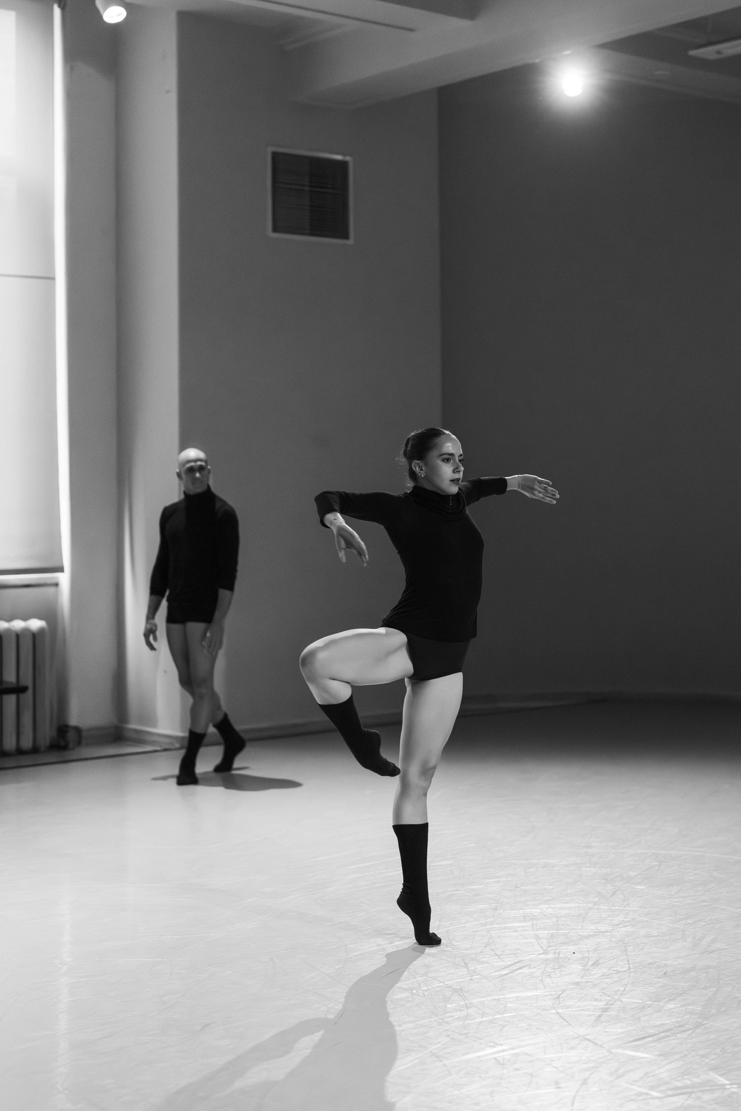 Black and white photo series showing dance movements in an empty studio with dramatic lighting and shadows.