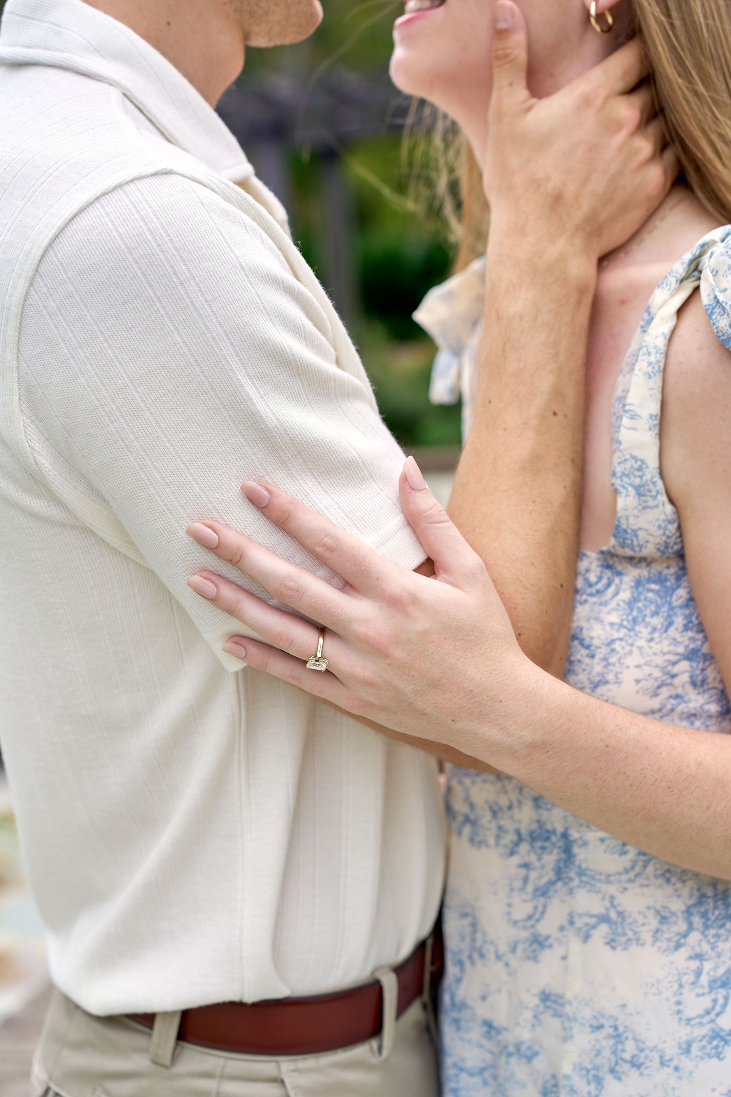 Close-up shot showing tender embrace with hands against white and blue floral clothing. North Carolina Wedding Photographer.
