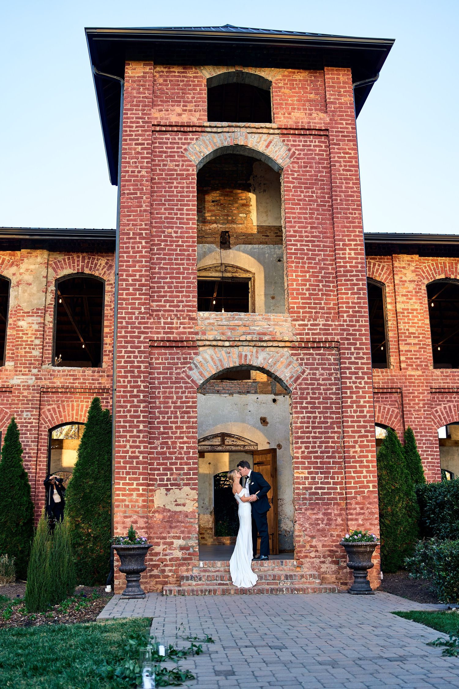 Beautiful brick mansion venue with arched entryways and formal landscaping creates an elegant wedding backdrop.