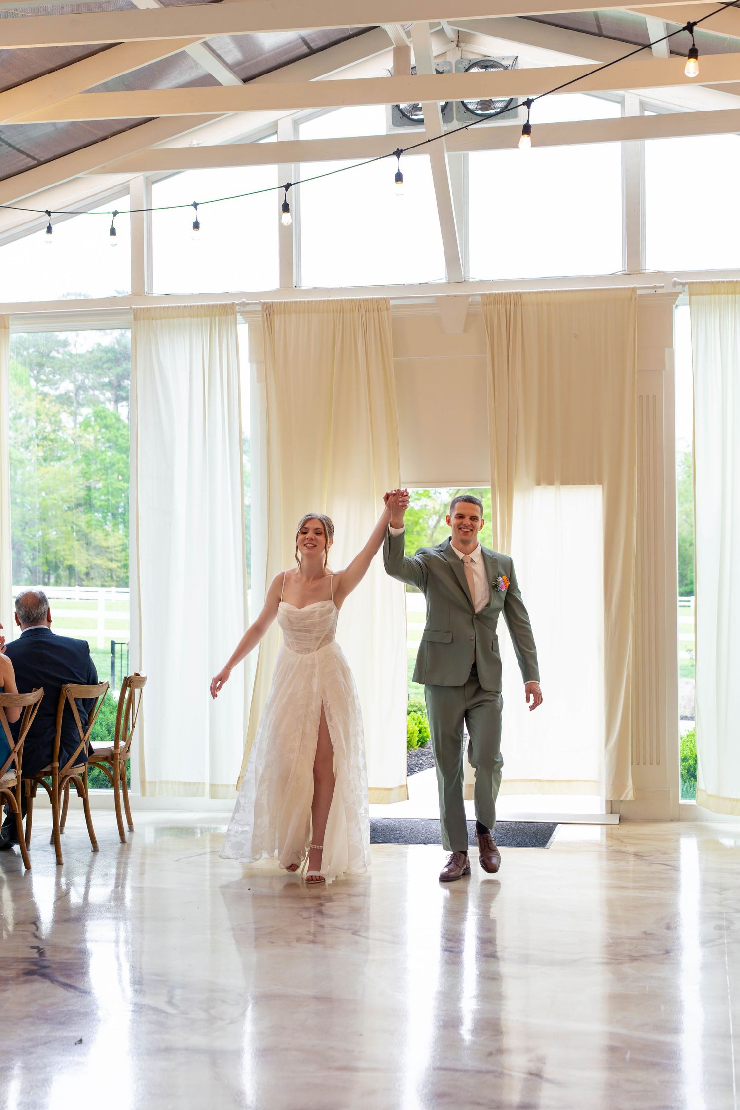 Bride and groom celebrating their grand entrance into the wedding reception hall together.