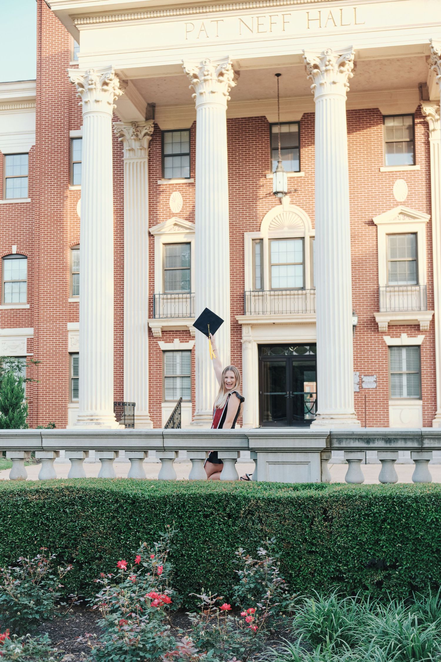 Graduate celebrates in front of Pat Neff Hall at Baylor University tossing her cap. North Carolina Photographer.