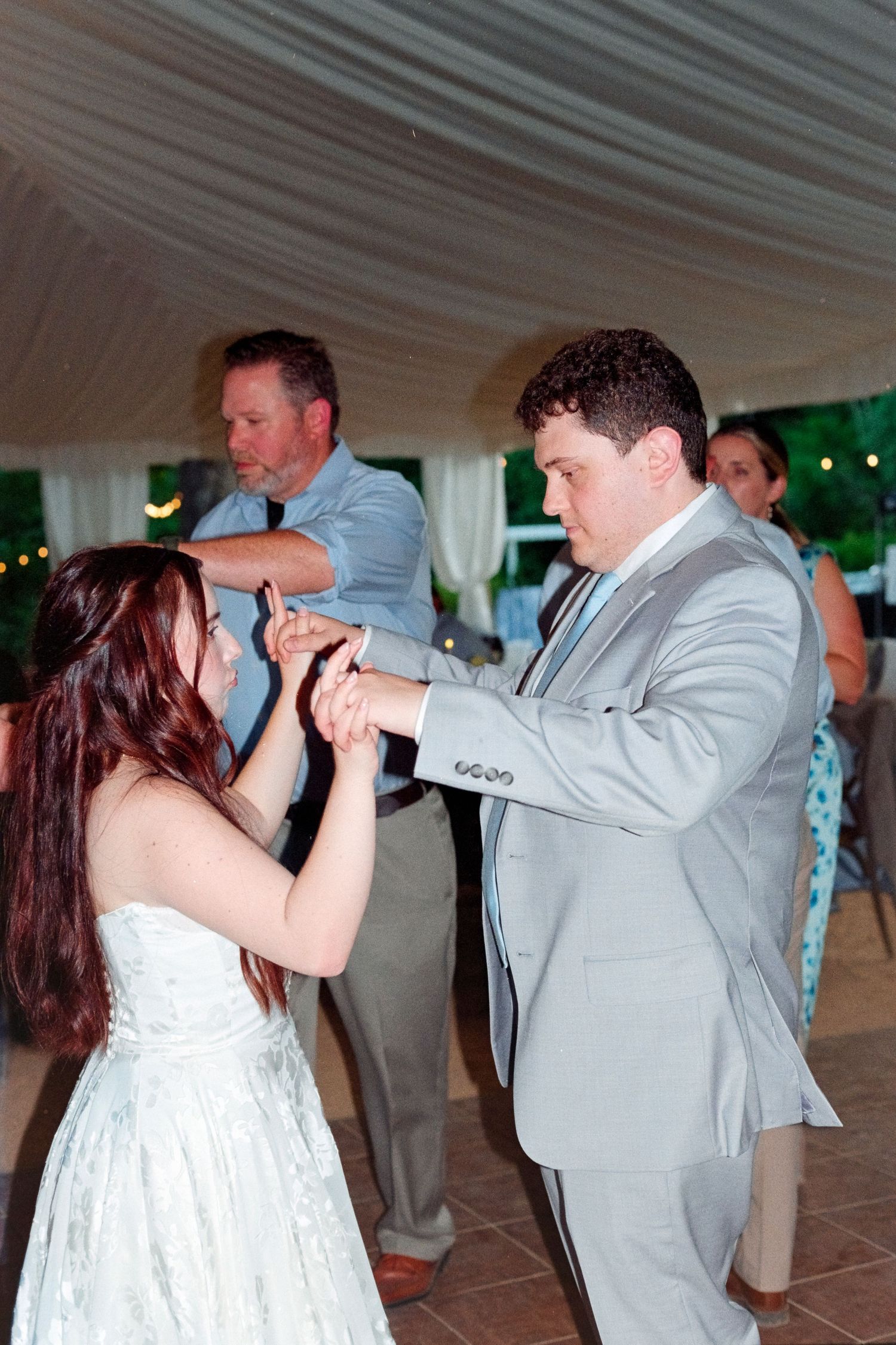 Bride and groom share a dance at their elegant tented wedding reception.