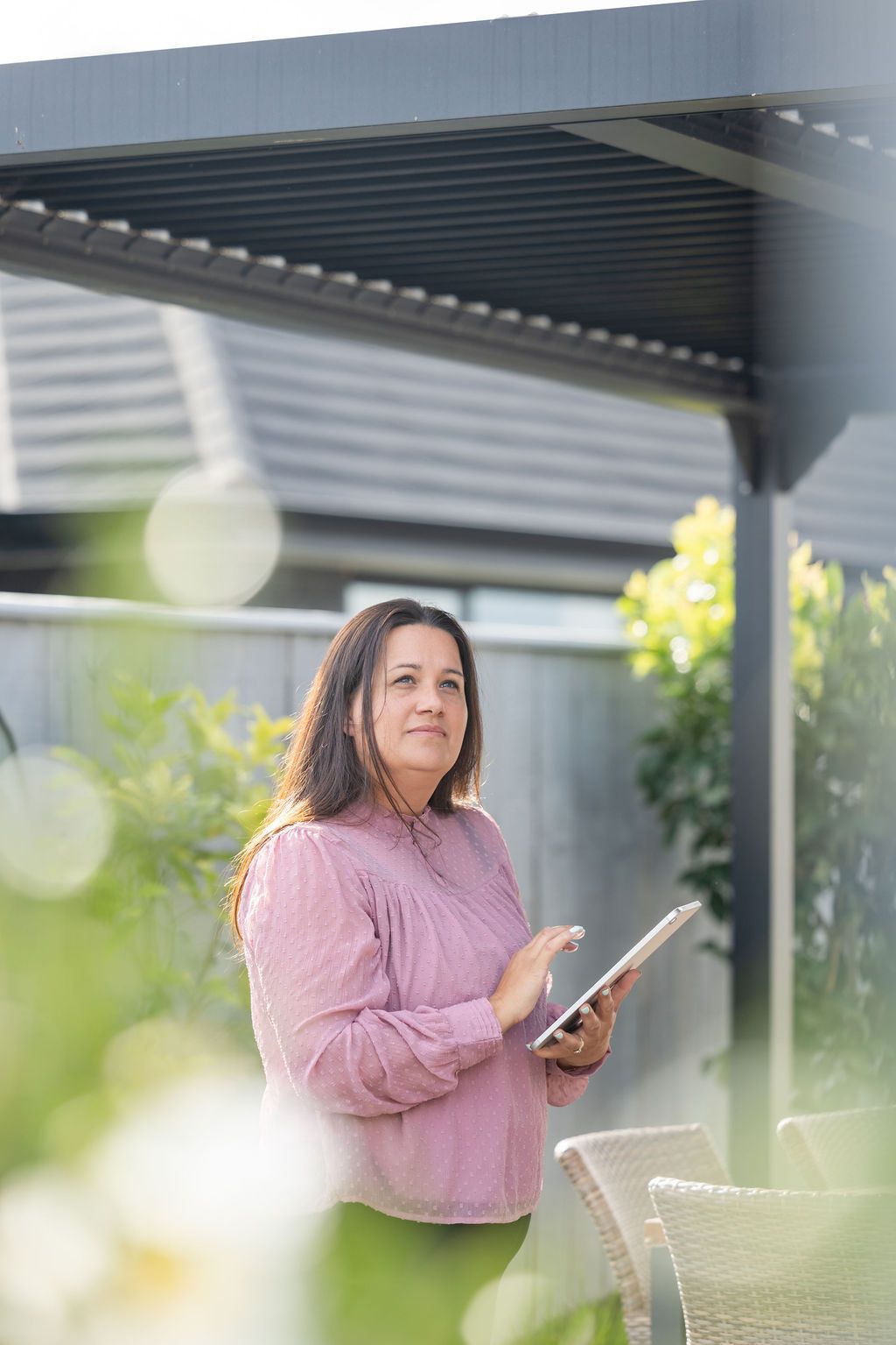 Claire House Photograph business photograph of a woman real estate agent holding a tablet, assessing a property.