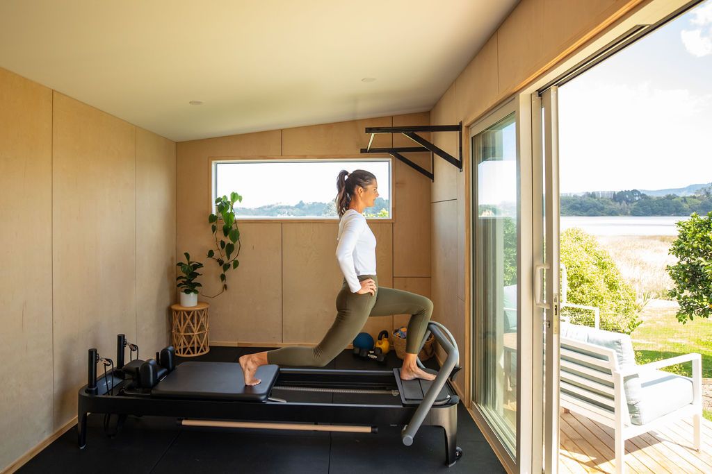 Claire House Photograph business photograph of a woman personal trainer using a pilates reformer.