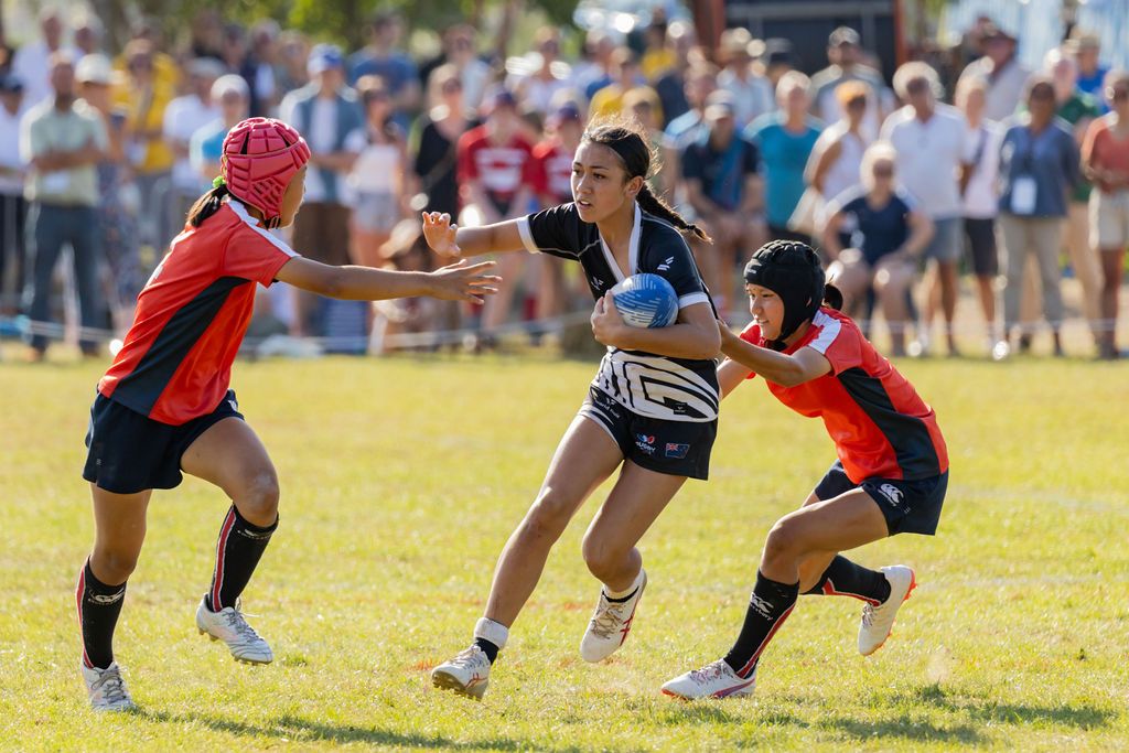 Claire House Photography sports event photograph of a girl fending a tackler in sevens rugby.