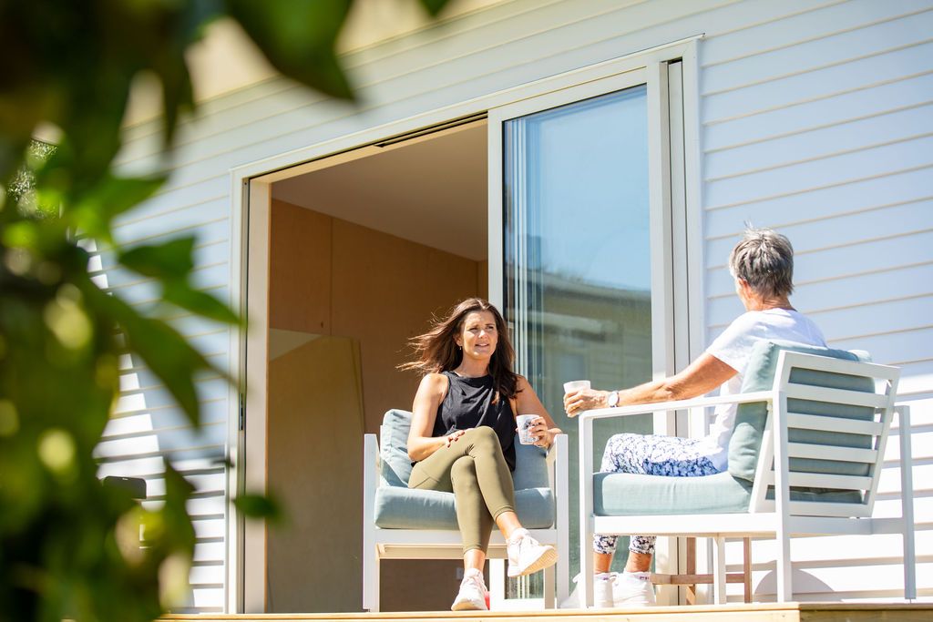 Claire House Photography business photograph of trainer talking with a client outside, drinking a healthy smoothie.