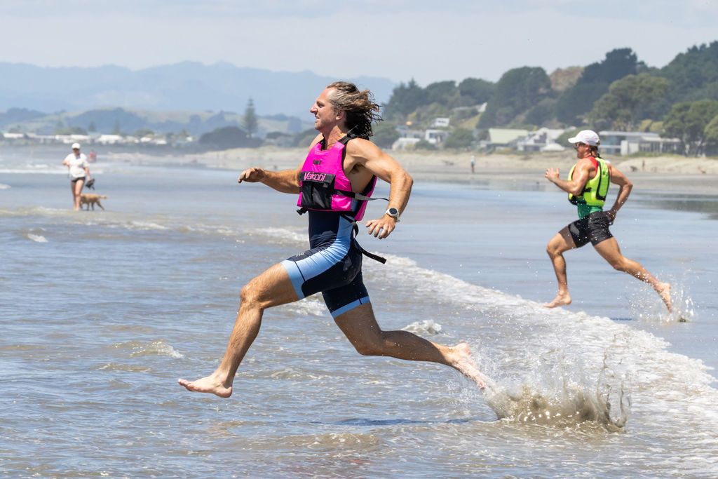 Claire House Photography event photograph two beach sprint rowers running to their boat.