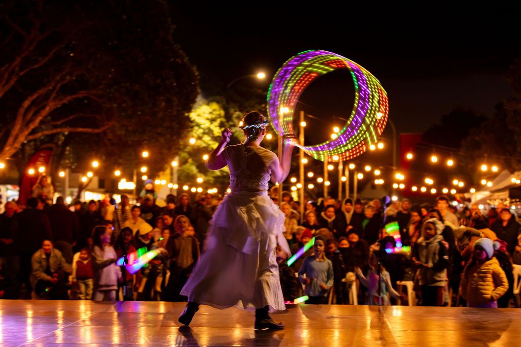 Claire House Photography community event photograph of performer with light up hoop being watched by a crowd.