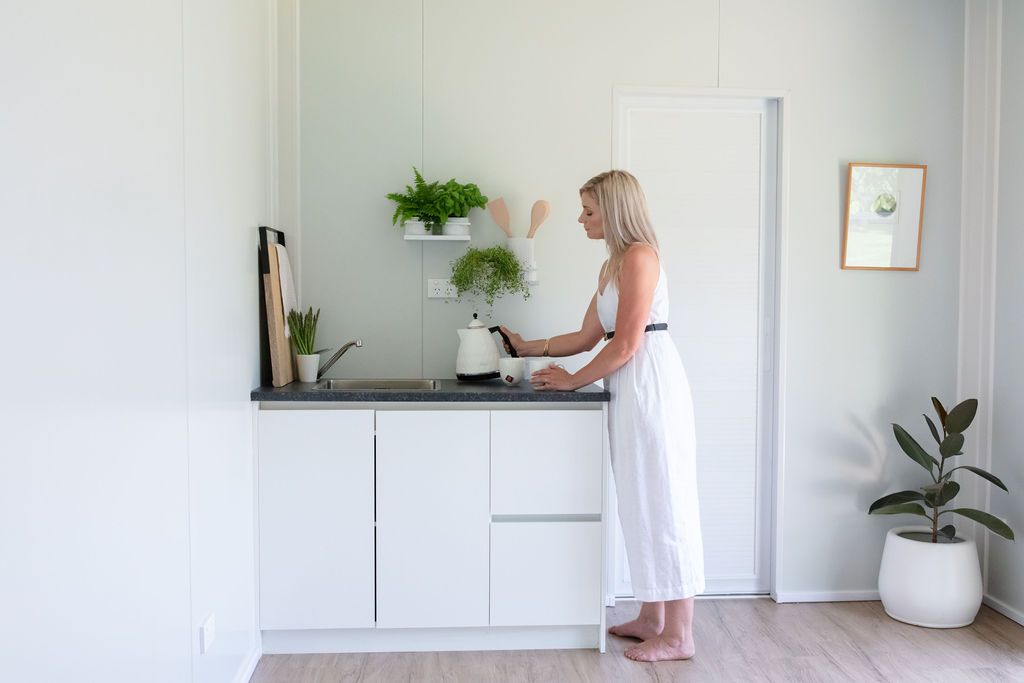 Claire House Photograph business photograph of a woman wearing white using the kettle inside a Podlife Pod.