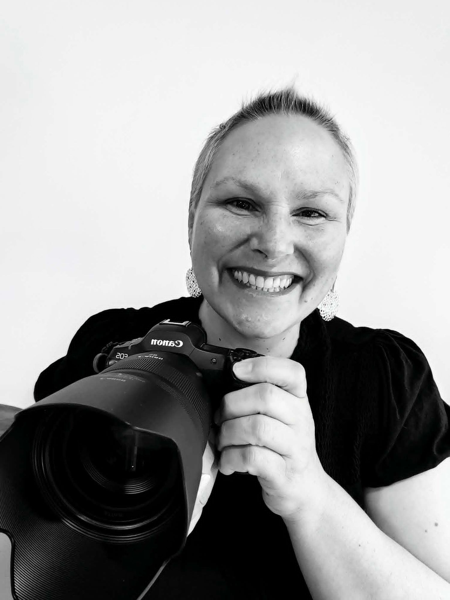 Photograph of Claire House from Claire House Photography smiling and holding a canon camera.