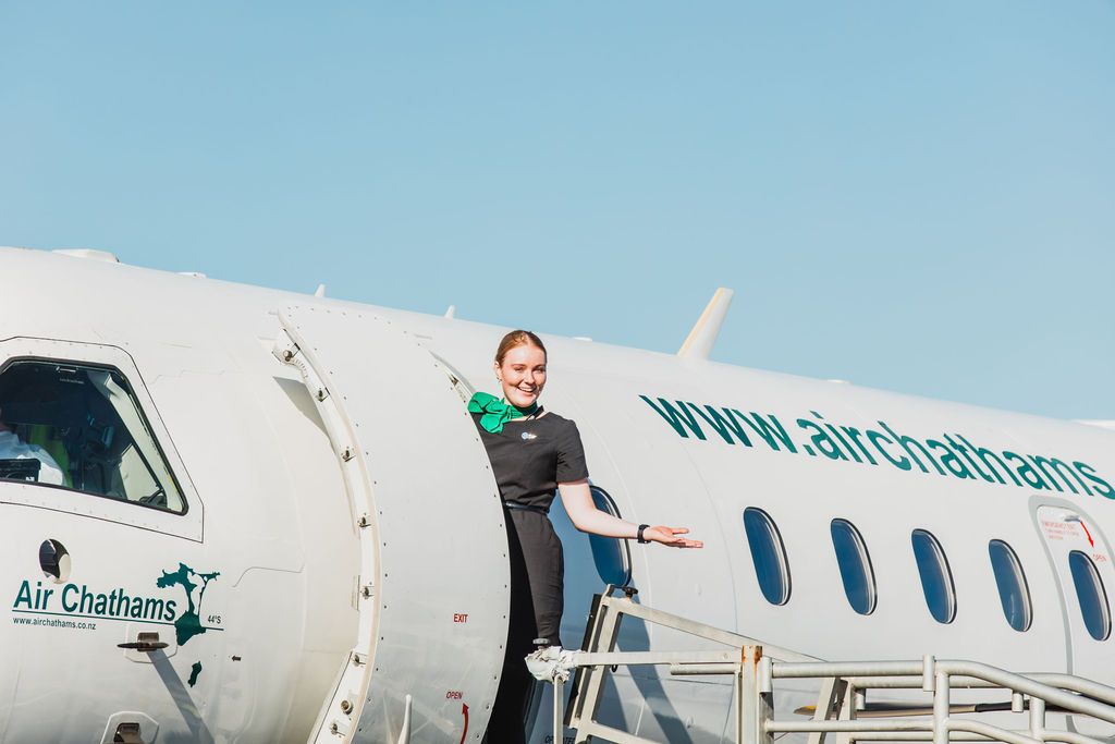 Claire House Photograph business photograph of an Air Chathams hostess at the entrance to the plane.