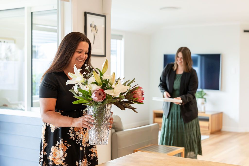 Claire House Photography business photograph of real estate agents preparing a living room - arranging flowers.