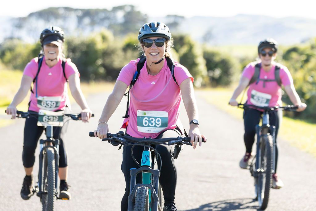 Claire House Photography event photograph of three women in pink tshirts mountain biking in an adventure race.