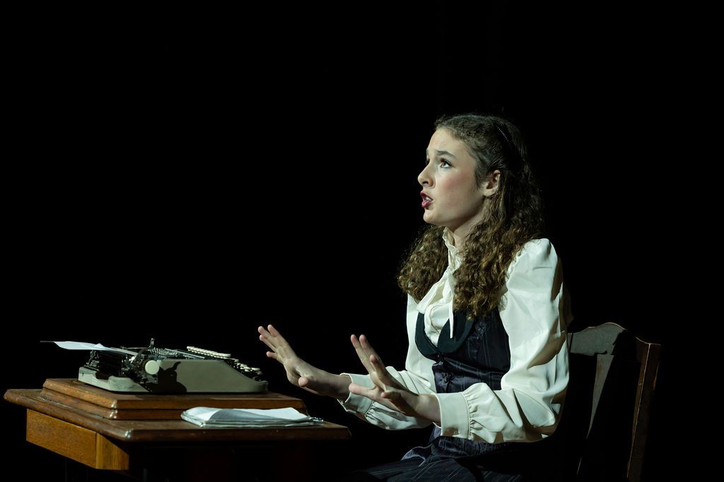 Claire House Photography event photograph of a stage production of a girl singing at a typewriter.