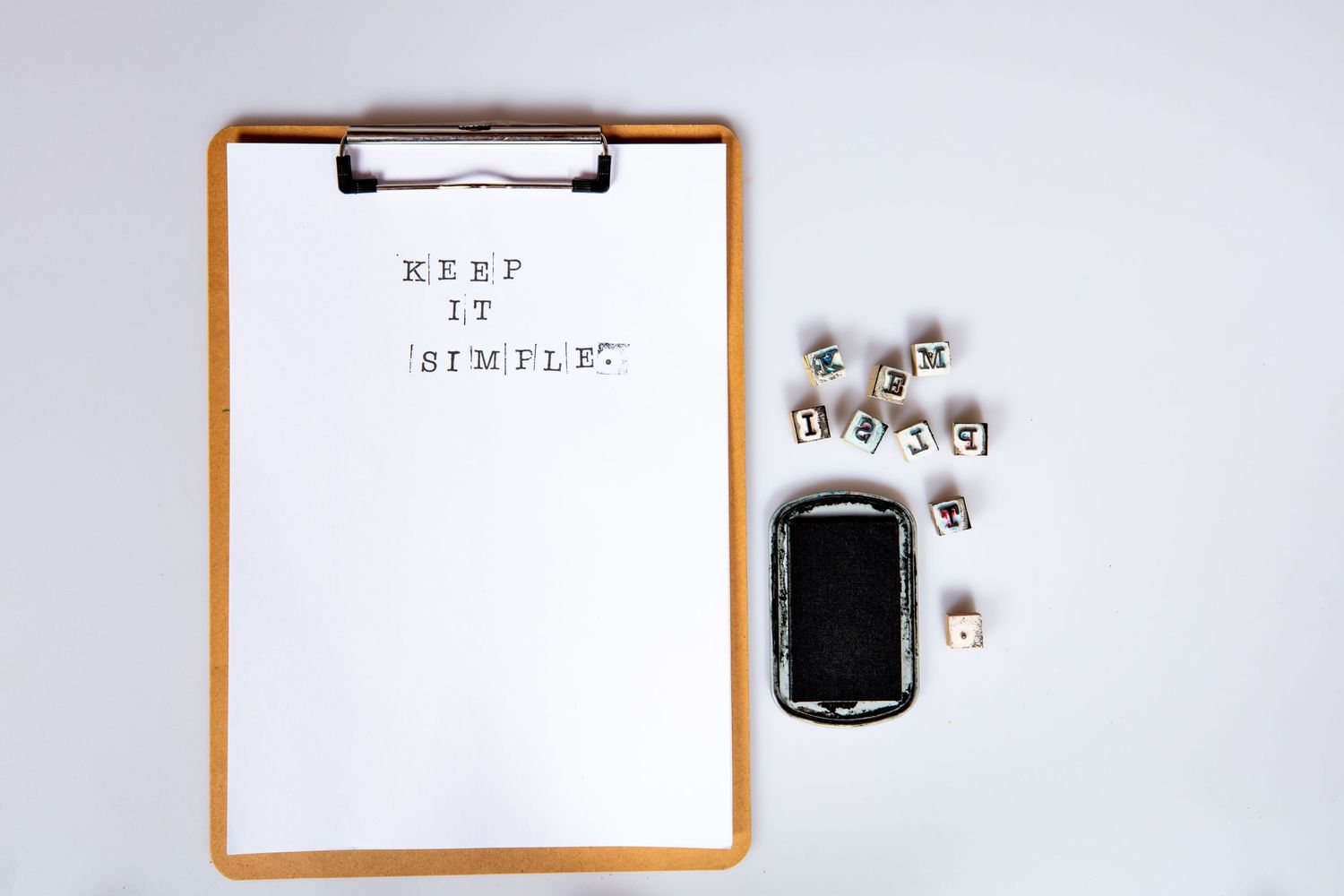 Claire House Photography stamp photograph of a clip board with the message keep it simple.