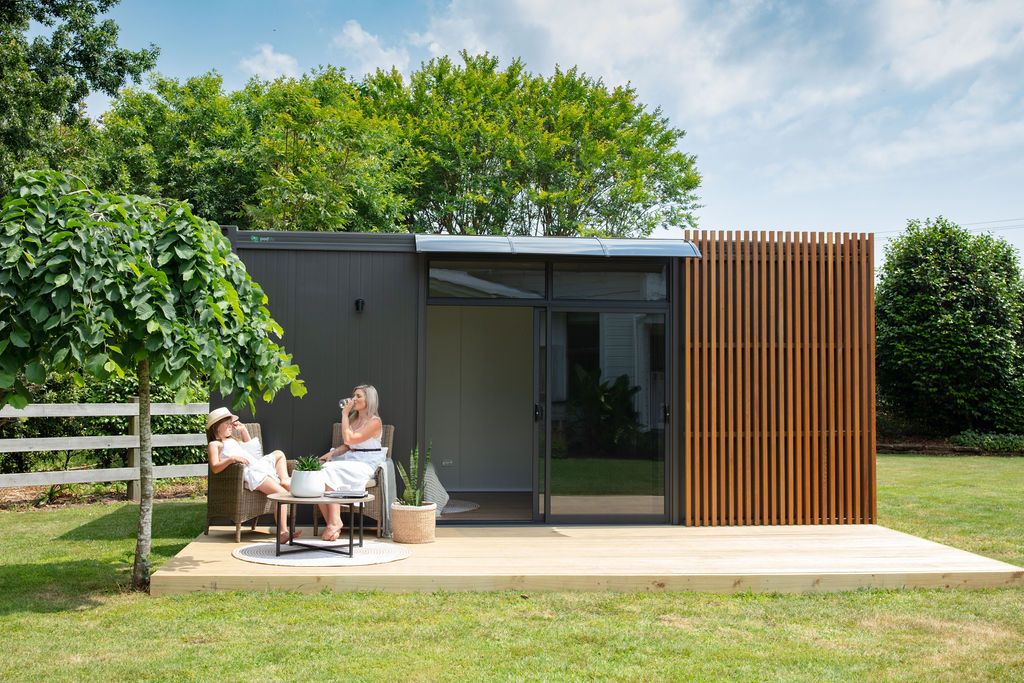 Claire House Photograph business photograph of a Podlife pod with a mother and daughter reading outside in the sunshine.
