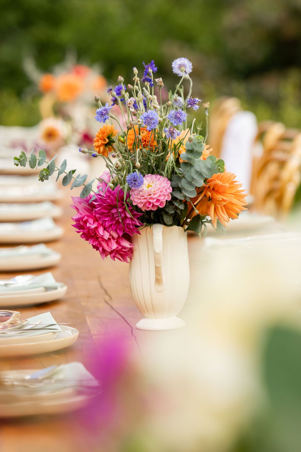 Claire House Photography event photograph of a vase ofcolourful flowers at a beautifully laid outdoor table.