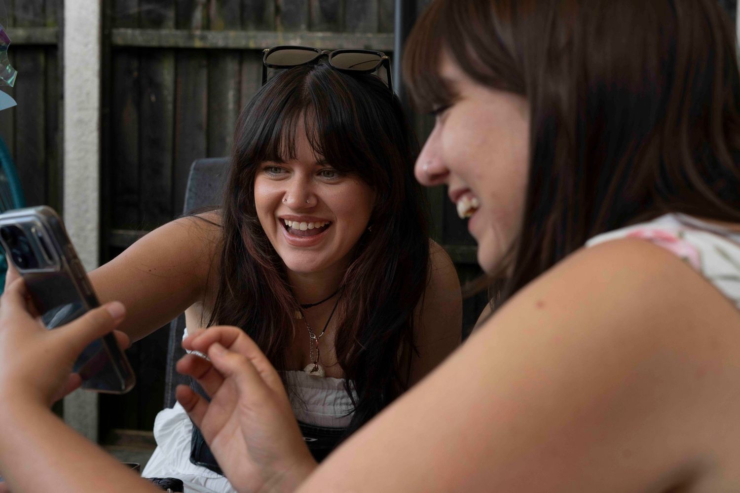 2 women looking at phone and laughing