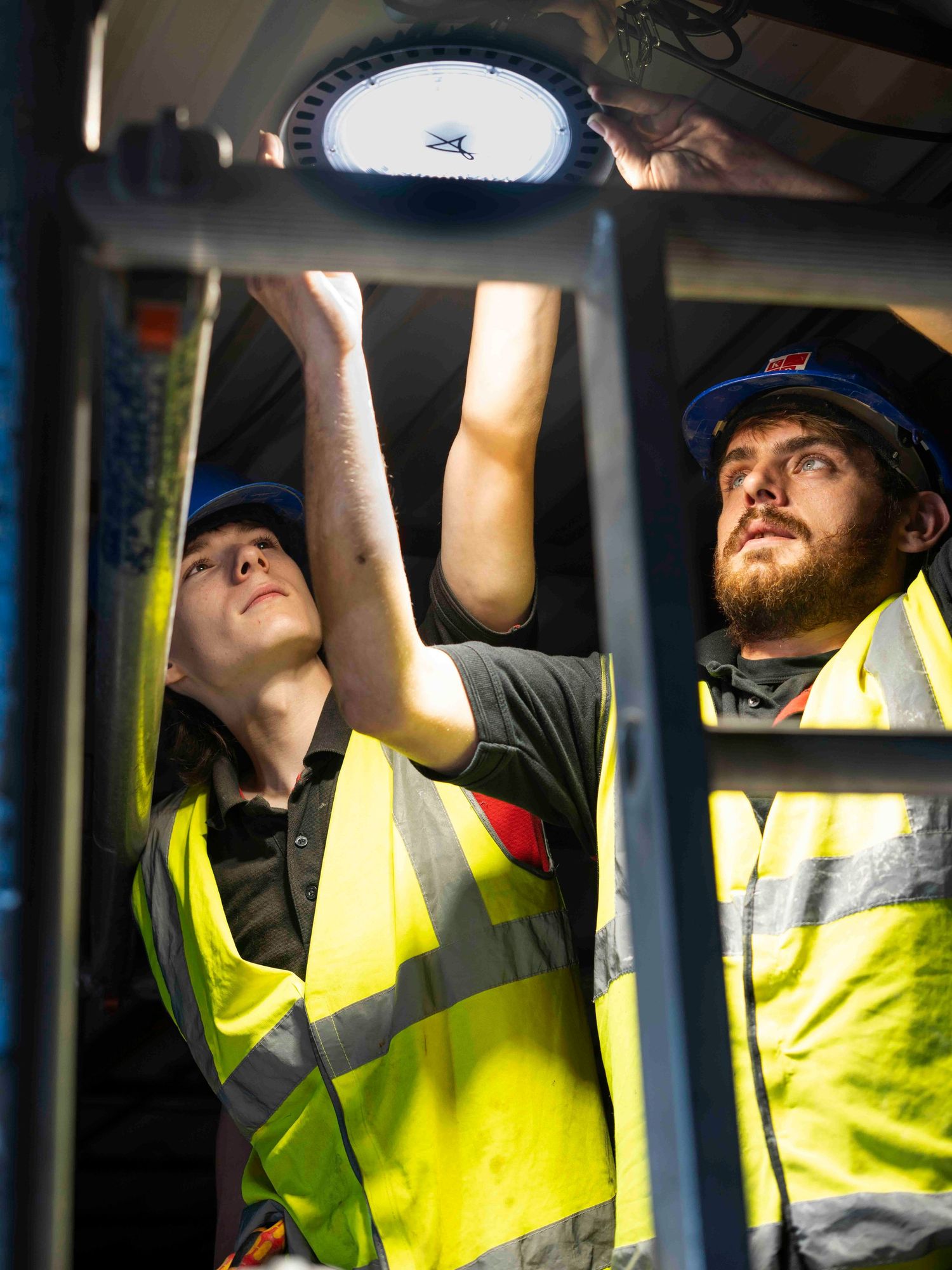 Image of 2 electricians fixing a light