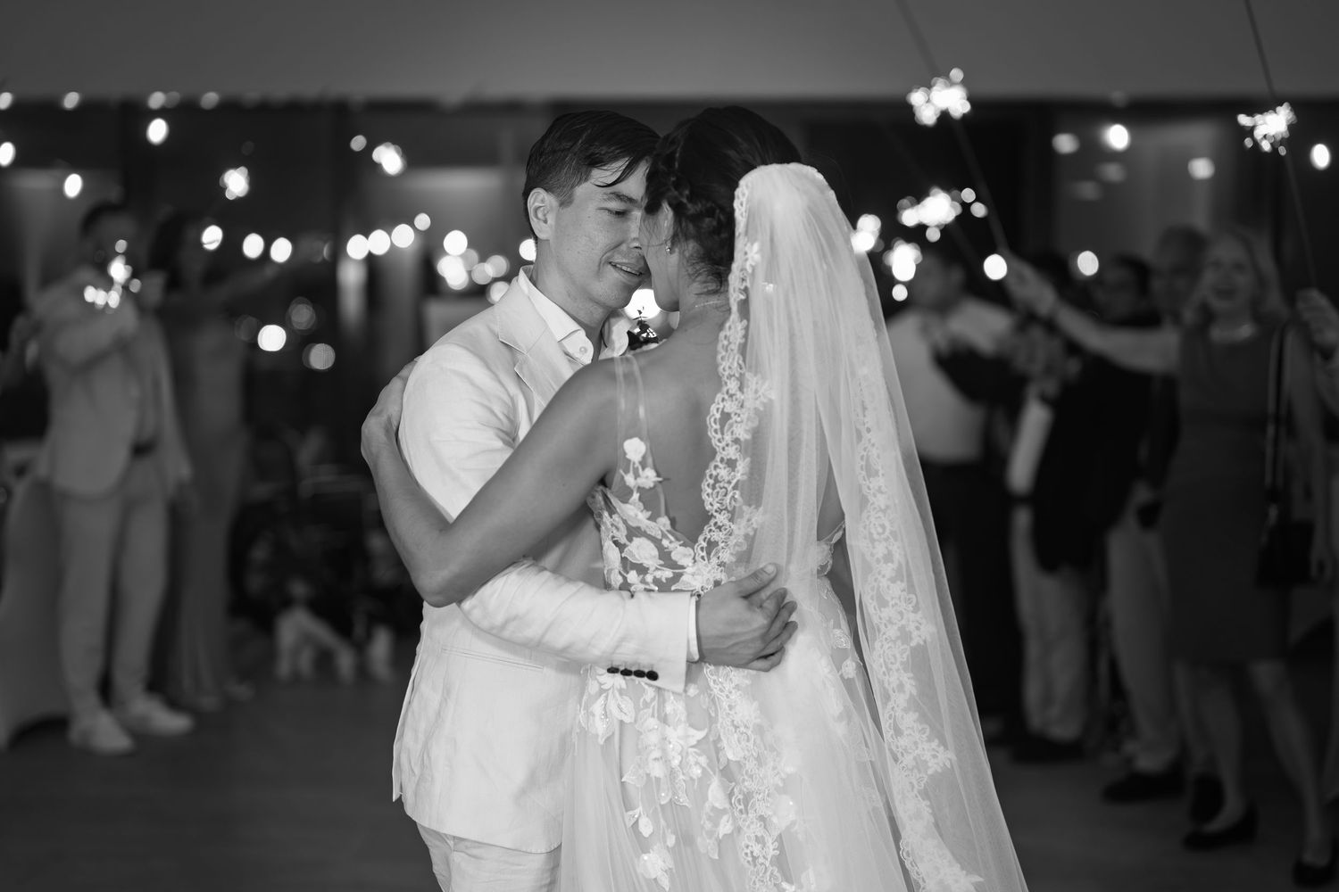 Couple shares their first dance surrounded by sparklers at a romantic wedding reception.