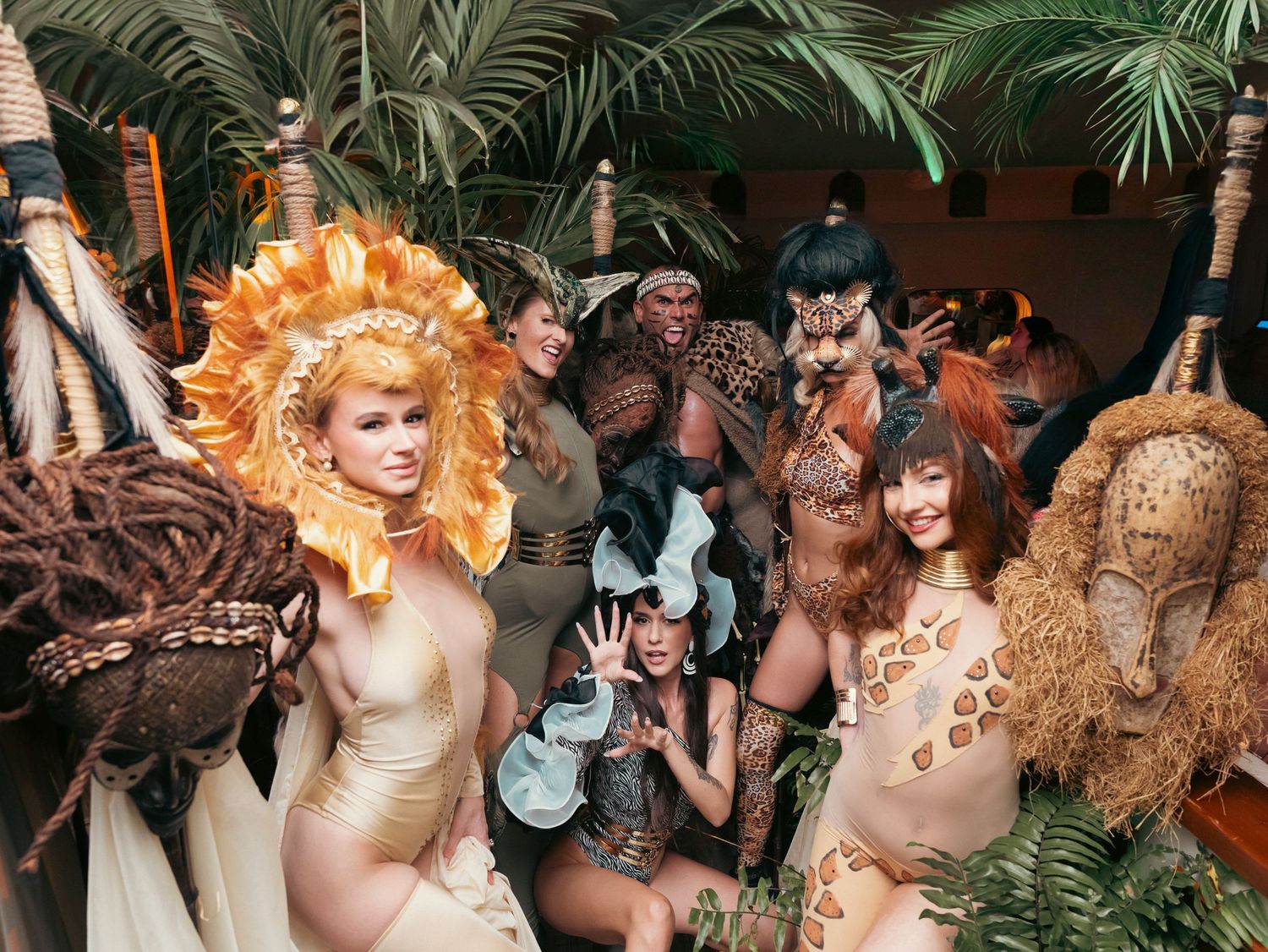 Group of performers in elaborate jungle-themed costumes posing together at an event.