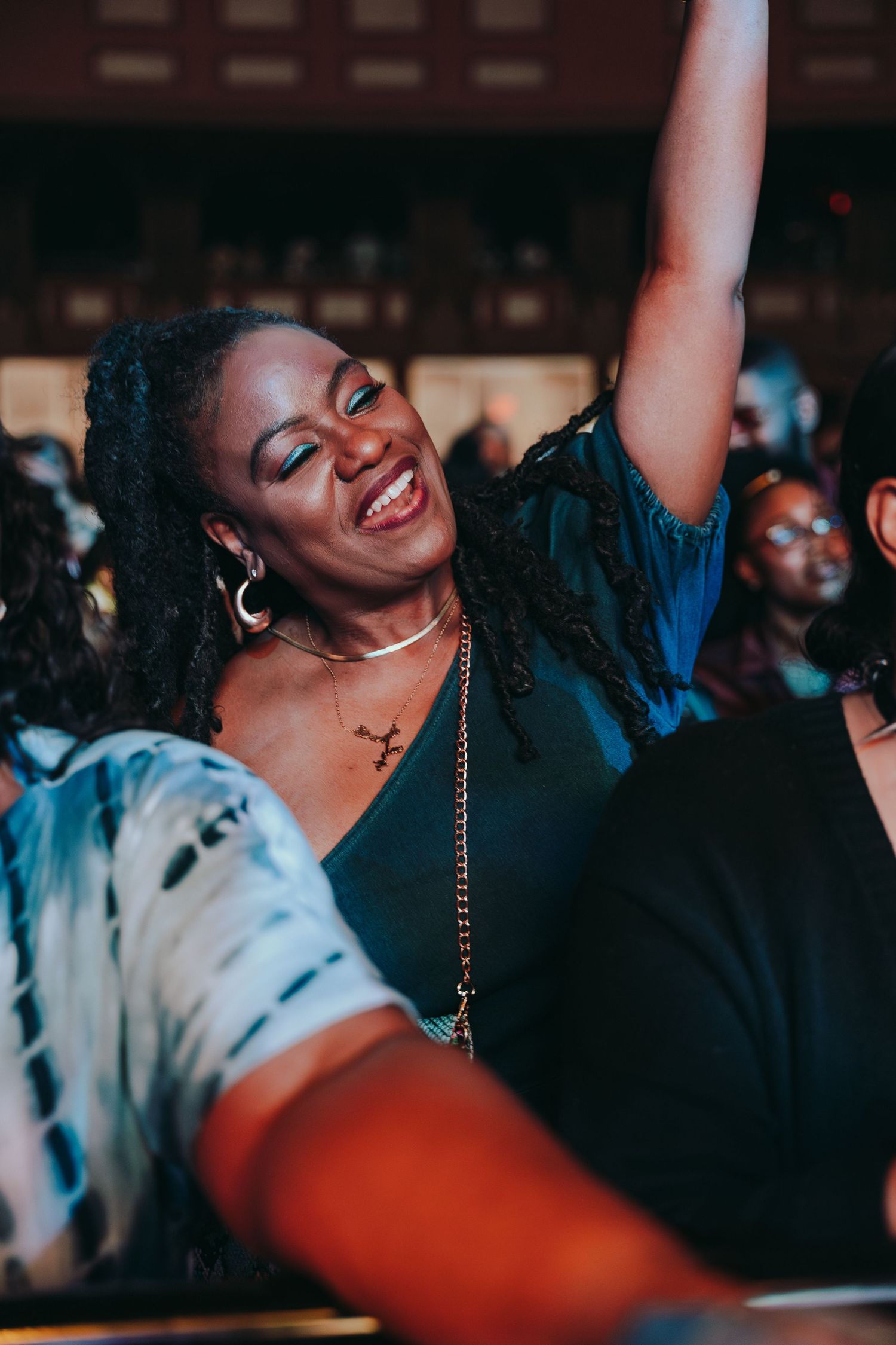 A joyful woman dancing and smiling at a live concert event.