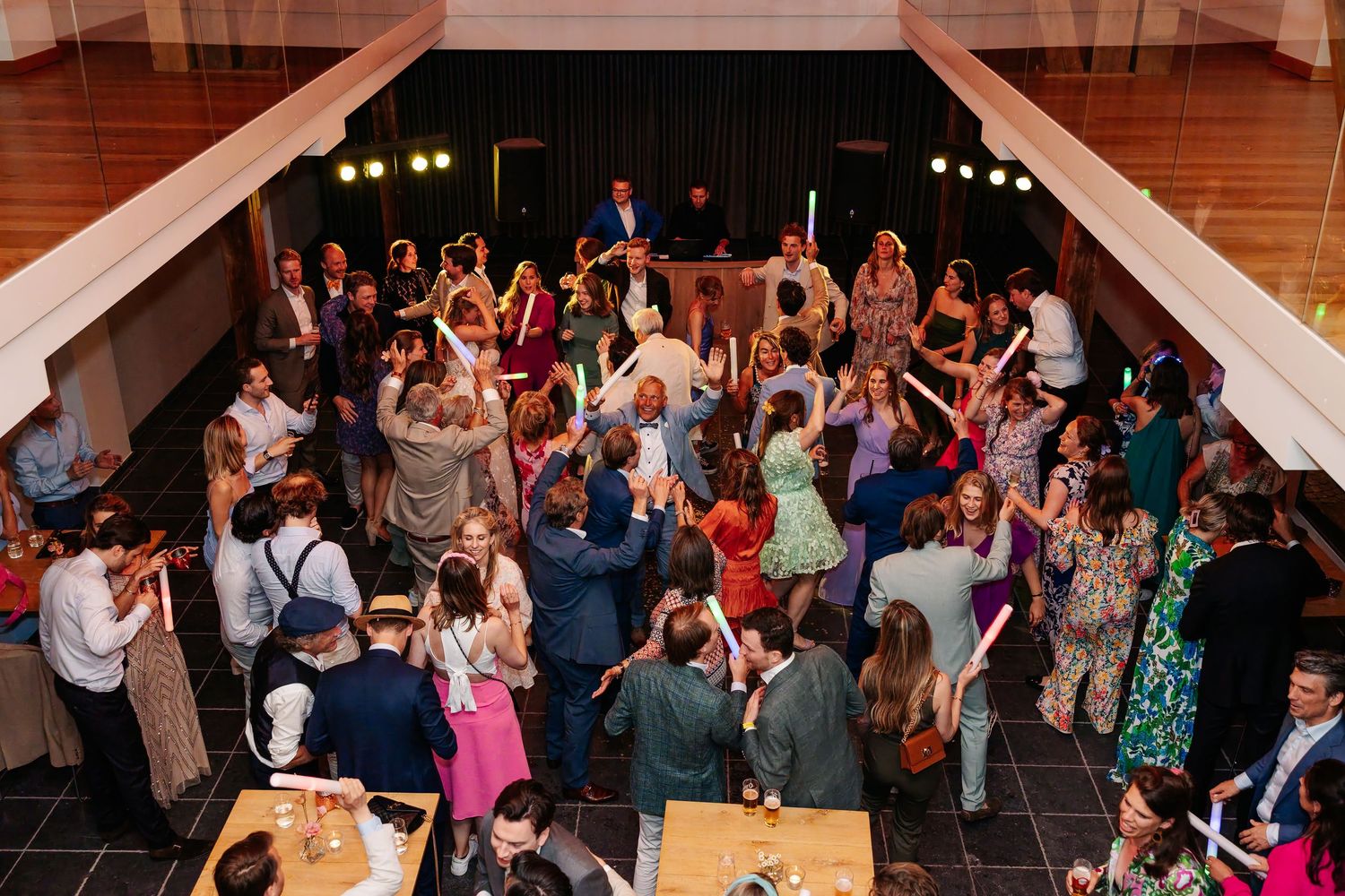 Overhead view of energetic wedding reception dance floor packed with celebrating guests.