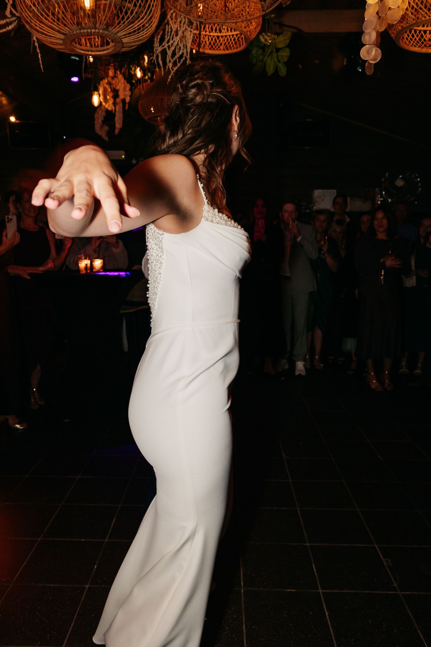 Bride in white gown dancing elegantly on the dance floor at a wedding reception.