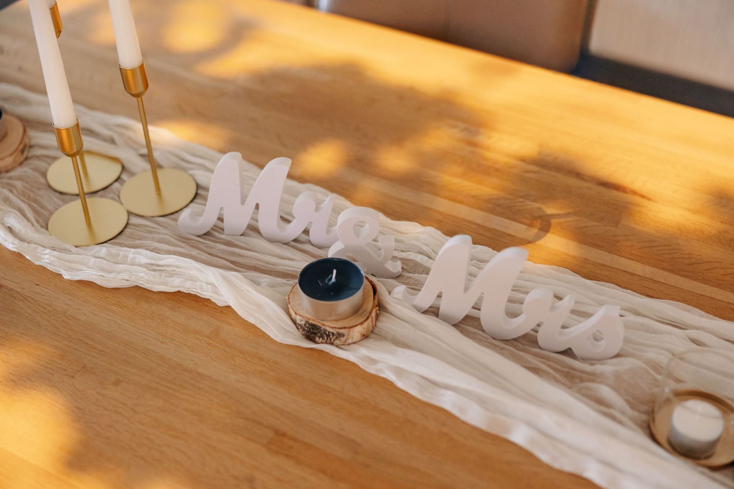 Decorative Mr and Mrs wooden sign on table with candles at wedding reception.