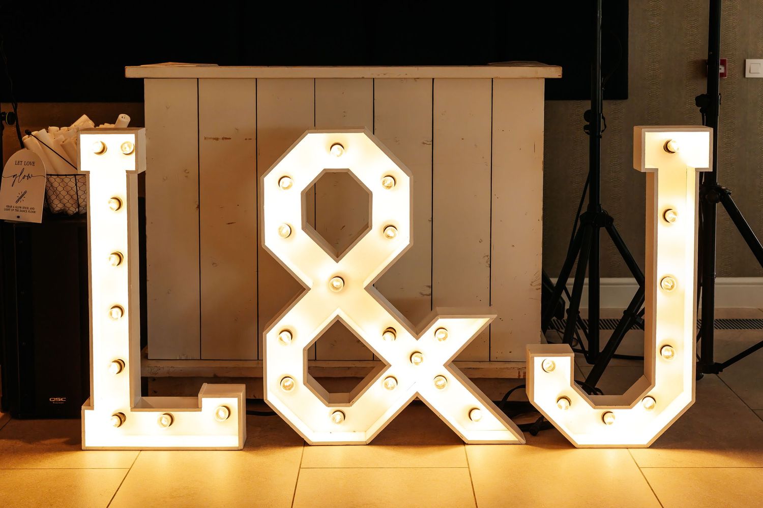 Illuminated marquee letter lights spelling L&J for a wedding reception décor.