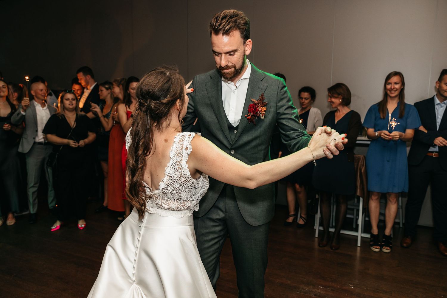 Bride and groom sharing their first dance at wedding reception surrounded by guests.