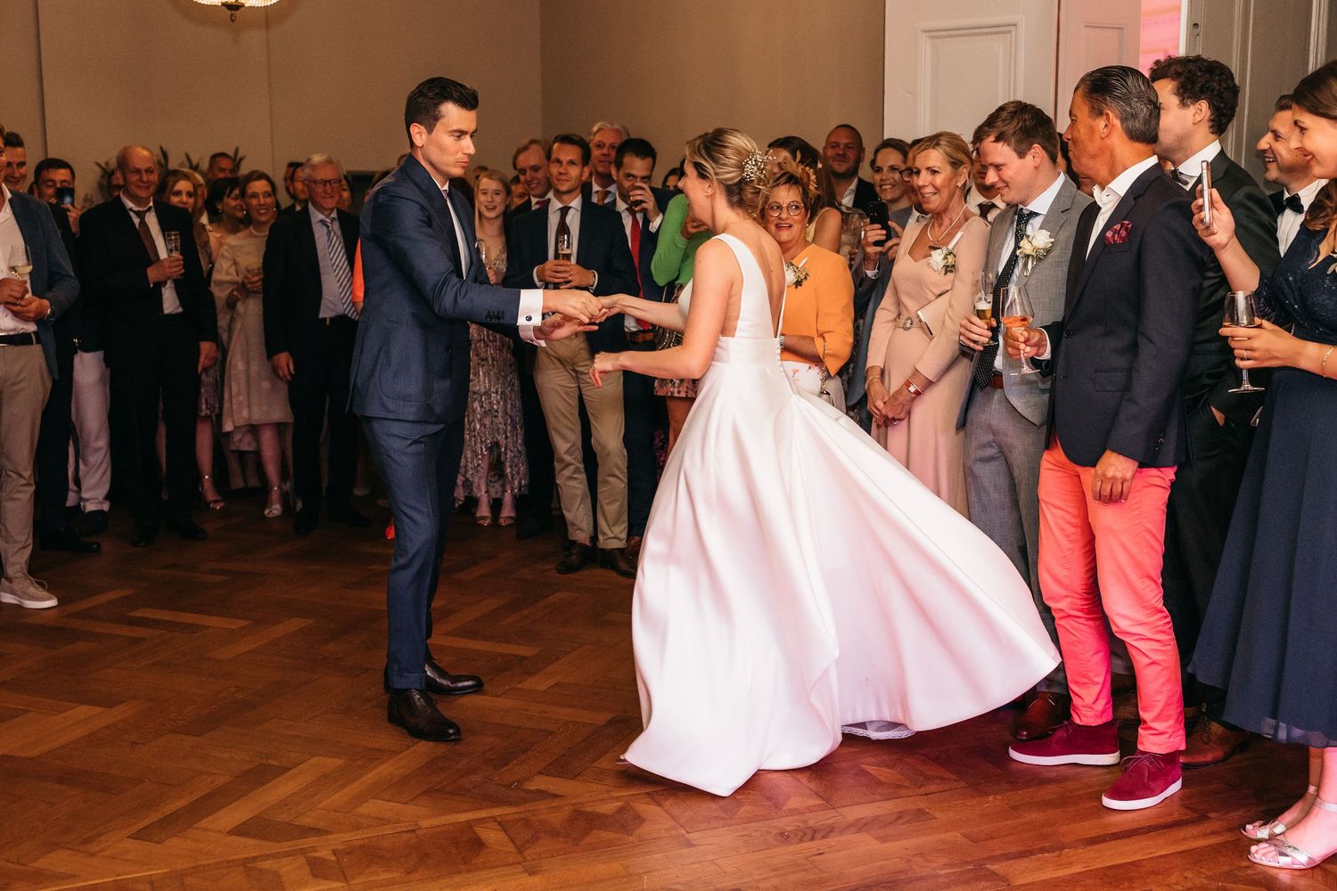 Bride and groom holding hands dancing together at elegant wedding reception.
