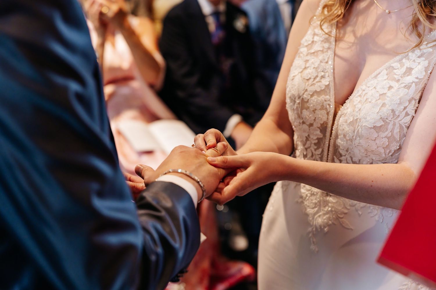 Bride and groom exchanging wedding rings during romantic church ceremony.