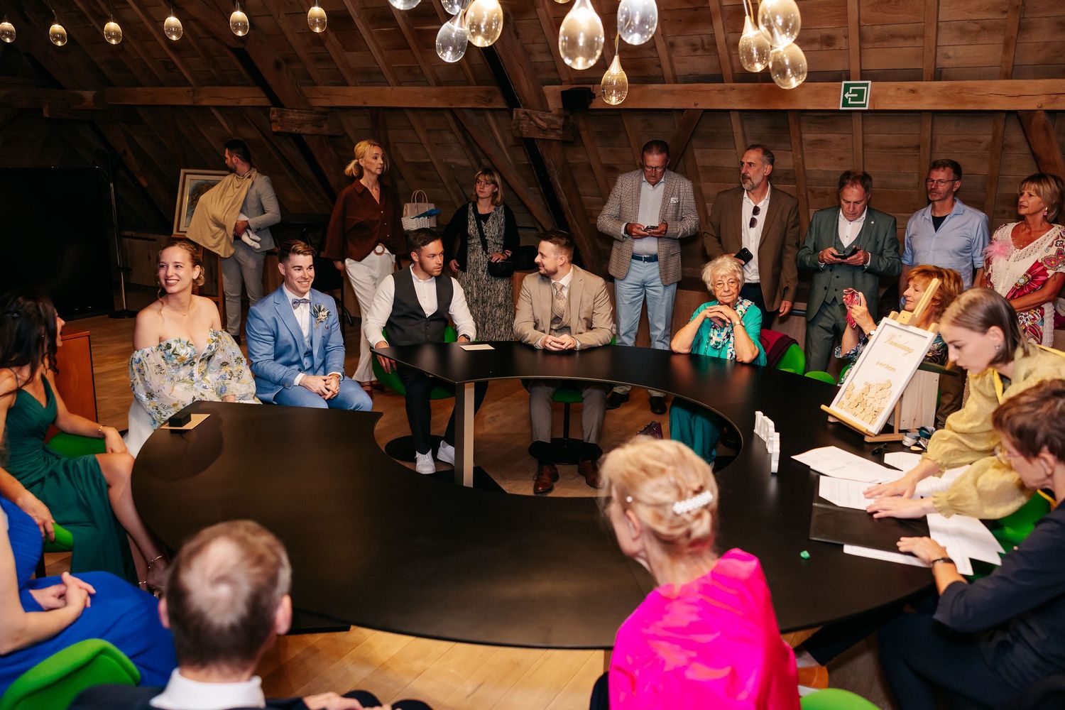 Wedding guests seated in circular arrangement during intimate indoor ceremony.