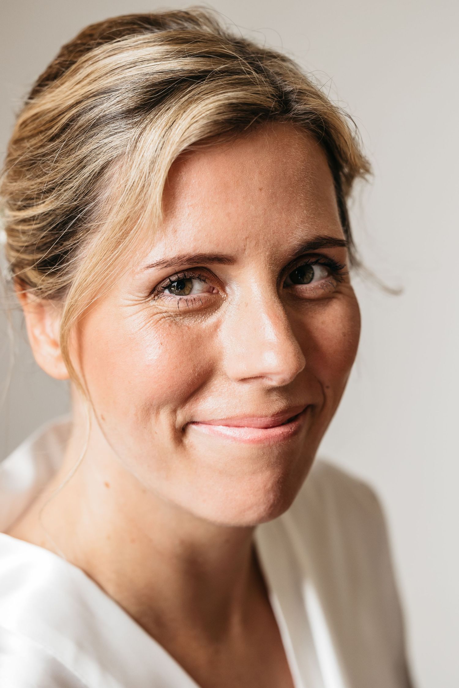 Close-up portrait of a smiling blonde bride on her wedding day.